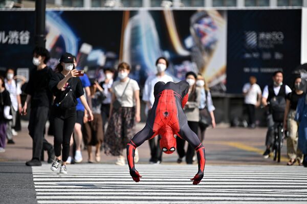 Человек в костюме Человека-Паука прыгает на перекрестке Сибуя в Токио
