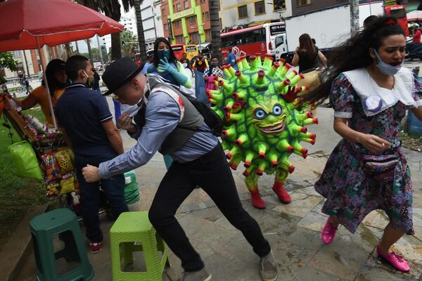 Артист выступает на площади Ботеро в рамках информационной кампании по предотвращению распространения коронавируса в Медельине