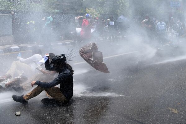 Полиция использует водометы для разгона демонстрантов протестующих против политики правительства по борьбе с коронавирусом COVID-19 в Катманду, Непал