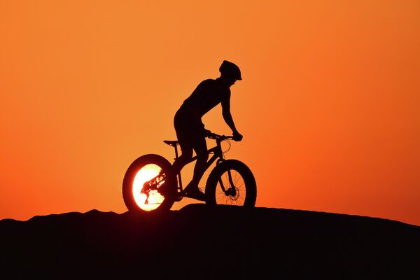 Велосипедист в пустыне Аль-Кудра в Дубае