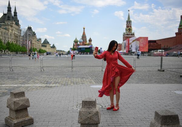 Девушка фотографируется на Красной площади в Москве