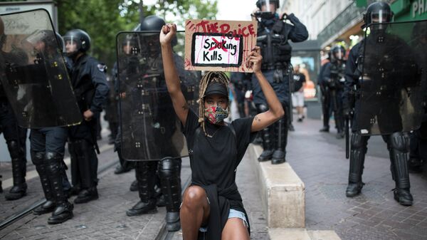 Протестующий на коленях перед французской полицией с табличкой Полиция убивает в Марселе, Южная Франция