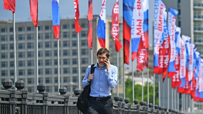 Прохожий на Новоарбатском мосту в Москве во время праздничных гуляний в честь празднования Дня России