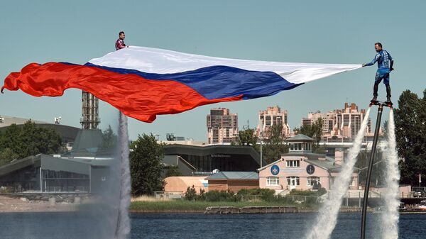 Спортсмены сборной России по гидрофлаю открывают празднование Дня России поднятием флага на Петровской косе в Санкт-Петербурге