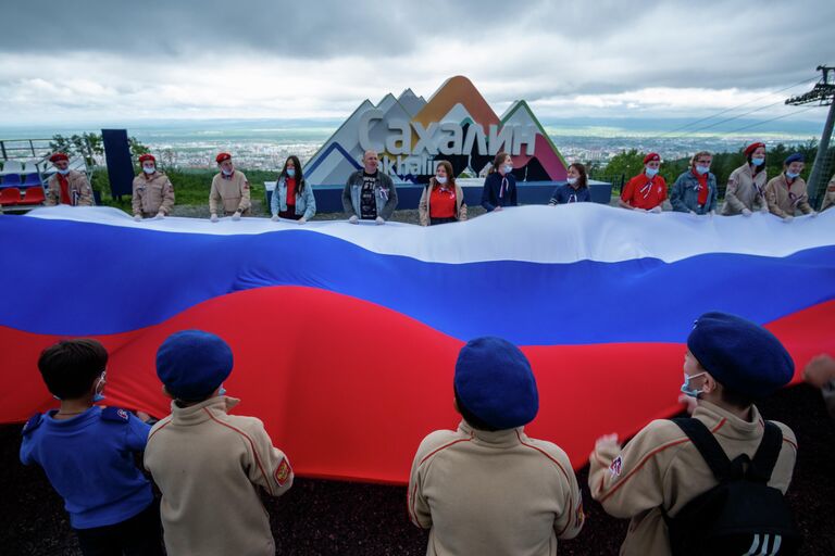 Участники акции Флаг России на горе Большевик в Южно-Сахалинске