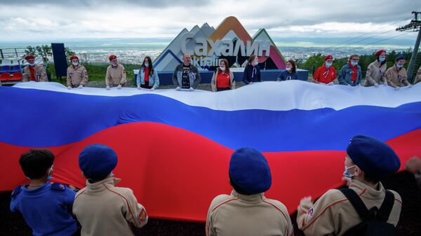 Участники акции Флаг России на горе Большевик в Южно-Сахалинске