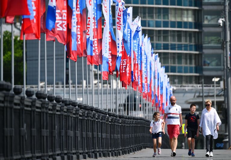 Горожане на Новоарбатском мосту в Москве, украшенном ко Дню России