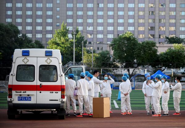 Медицинские работники в спортивном центре Guang'an, где проходит тестирование людей на коронавирус, живущих рядом или посещающих рынок Синьфади