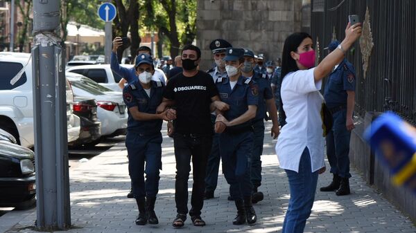 Сотрудники правоохранительных органов Армении задерживают участника акции у здания парламента в Ереване. 16 июня 2020