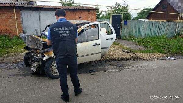 Сотрудник СК РФ осматривает автомобиль после ДТП в поселке Николаевка города Саранск
