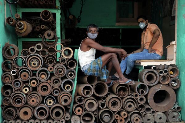 Работники магазина по продаже металлических труб на оптовом рынке в Калькутте