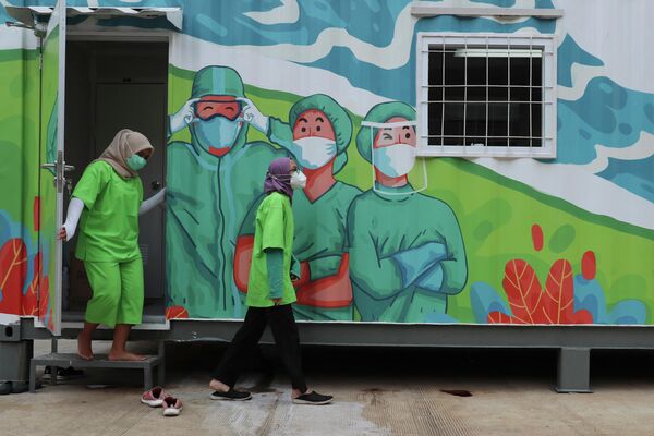 Медицинские работники выходят из лаборатории в Джакарте, Индонезия 