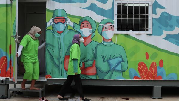 Медицинские работники выходят из лаборатории в Джакарте, Индонезия 