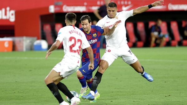 Barcelona's Argentinian forward Lionel Messi (C) challenges Sevilla's Spanish defender Sergio Reguilon (L) and Sevilla's Brazilian defender Diego Carlos (R) during the Spanish league football match between Sevilla FC and FC Barcelona at the Ramon Sanchez Pizjuan stadium in Seville on June 19, 2020. (Photo by CRISTINA QUICLER / AFP)