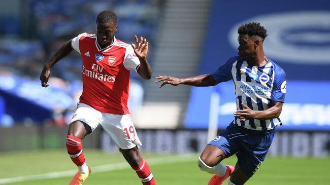 Arsenal's French-born Ivorian midfielder Nicolas Pepe (L) and Brighton's Ivorian midfielder Yves Bissouma compete during the English Premier League football match between Brighton and Hove Albion and Arsenal at the American Express Community Stadium in Brighton, southern England on June 20, 2020. (Photo by Mike Hewitt / POOL / AFP) / RESTRICTED TO EDITORIAL USE. No use with unauthorized audio, video, data, fixture lists, club/league logos or 'live' services. Online in-match use limited to 120 images. An additional 40 images may be used in extra time. No video emulation. Social media in-match use limited to 120 images. An additional 40 images may be used in extra time. No use in betting publications, games or single club/league/player publications. / 