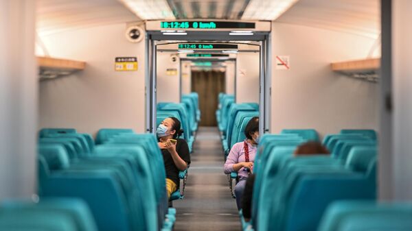 Пассажиры в защитных масках в вагоне поезда Шанхайского маглева