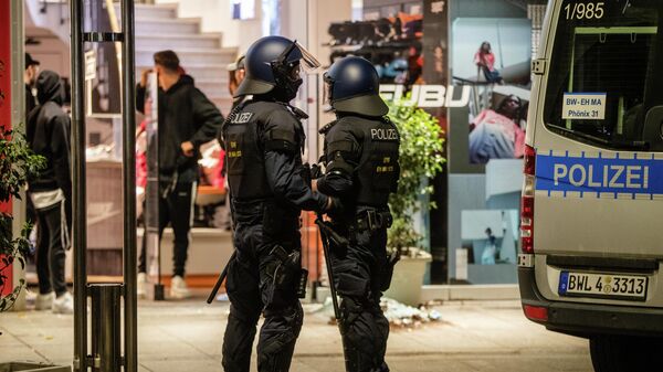 Полиция рядом с магазином,  разрушенным во время беспорядков в Штутгарте