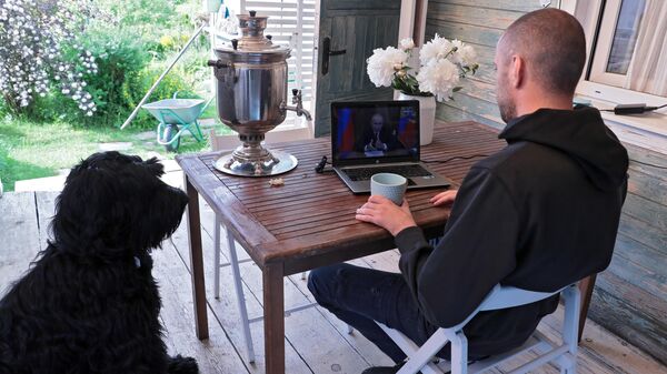 Мужчина смотрит трансляцию телеобращения президента РФ Владимира Путина к гражданам России