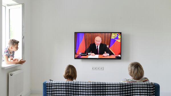 Семья смотрит трансляцию телеобращения президента РФ Владимира Путина к гражданам России