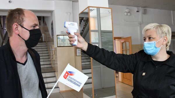 Измерение температуры участника голосования по внесению поправок в Конституцию РФ на избирательном участке №209 в Чите