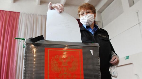 Женщина принимает участие в голосовании по внесению поправок в Конституцию РФ на избирательном участке №209 в Чите