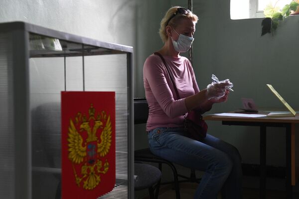 Женщина принимает участие в голосовании по внесению поправок в Конституцию РФ на избирательном участке №1503 в Новосибирске