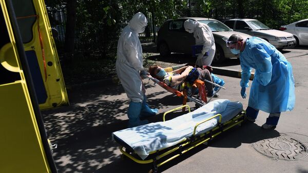Фельдшеры и водитель скорой медицинской помощи подстанции № 34 в Москве перемещают пациента с подозрением на коронавирус