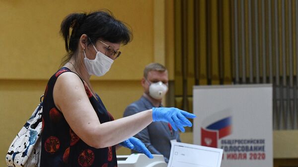 Женщина голосует по поправкам к Конституции на избирательном участке № 145 в Москве
