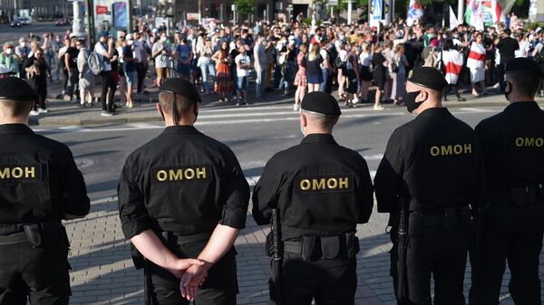 Сотрудники ОМОН Беларуси наблюдают во время акции протеста в Минске. 19 июня 2020