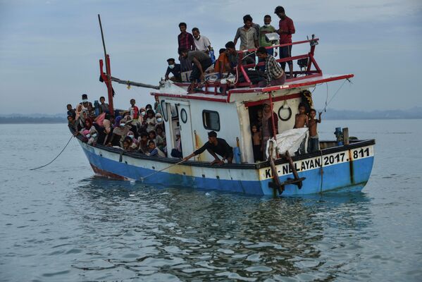 Лодка с людьми из народности рохинджа из Мьянмы прибывает на берег в Северный Ачех