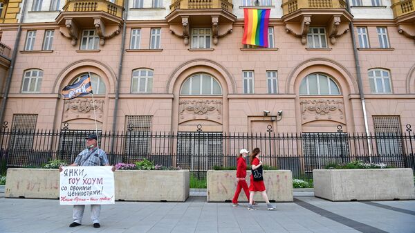 Одиночный пикет у здания посольства США в Москве, на котором вывешен флаг ЛГБТ-сообщества