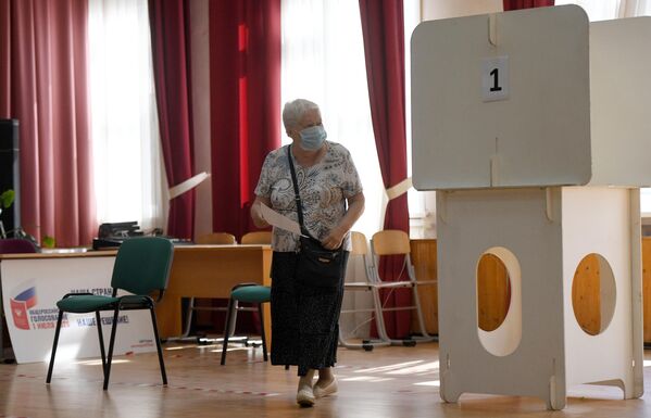 Женщина во время голосования по вопросу принятия поправок в Конституцию РФ на избирательном участке в Москве