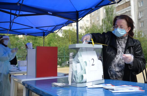Женщина во время голосования по вопросу принятия поправок в Конституцию РФ на мобильном избирательном пункте во дворе жилого дома в Екатеринбурге