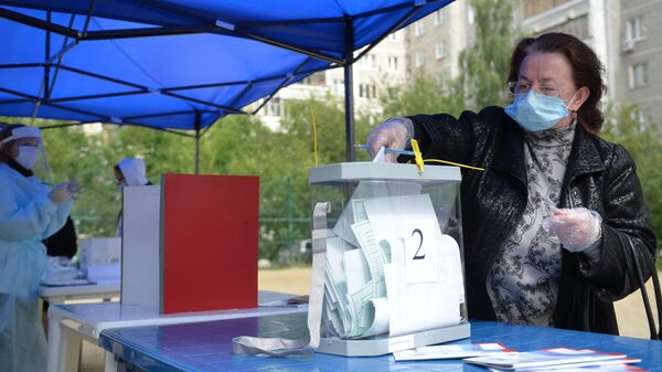 Женщина во время голосования по вопросу принятия поправок в Конституцию РФ на мобильном избирательном пункте во дворе жилого дома в Екатеринбурге