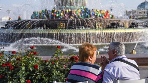 Люди отдыхают у фонтана Дружба народов на ВДНХ в Москве