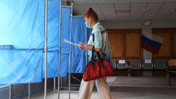 Женщина принимает участие в голосовании по внесению поправок в Конституцию РФ на избирательном участке