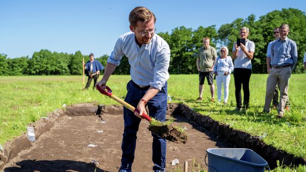 Министр климата и окружающей среды Норвегии Свейнунг Ротеватн начинает раскопки корабля викингов, обнаруженного в земле около Халдена