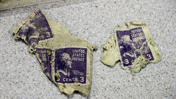 Марки в три цента, найденные при раскопках самолета, который врезался в гору в 1952 году в штате Аляска 