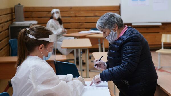 Женщина отмечается в списке избирателей на участке для голосования в Екатеринбурге
