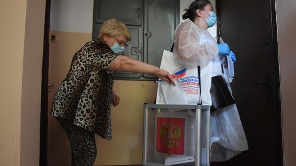 Женщина голосует по вопросу принятия поправок в Конституцию РФ у себя дома в Москве
