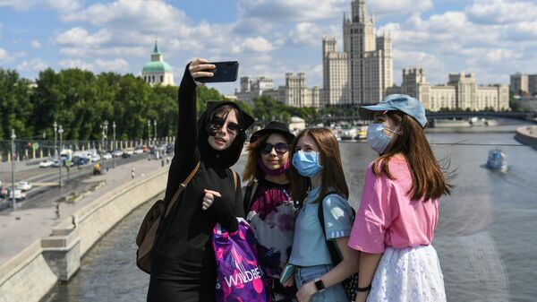 Девушки фотографируются на Парящем мосту в природно-ландшафтном парке Зарядье в Москве