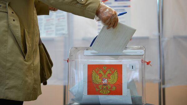 Женщина принимает участие в голосовании по внесению поправок в Конституцию РФ на избирательном участке №529 в поселке Калиново Свердловской области