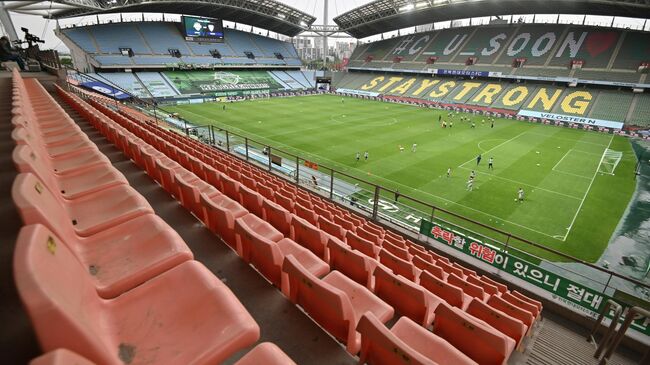 Empty stands are seen while football players warm up on the ground prior to the opening game of South Korea's K-League football match between Jeonbuk Hyundai Motors and Suwon Samsung Bluewings at Jeonju World Cup Stadium in Jeonju on May 8, 2020. - The towering stands of the 42,477-capacity Jeonju World Cup Stadium stood empty on May 8 and would remain that way as football restarted in South Korea after the coronavirus behind closed doors, but with unprecedented international TV audiences. (Photo by Jung Yeon-je / AFP)