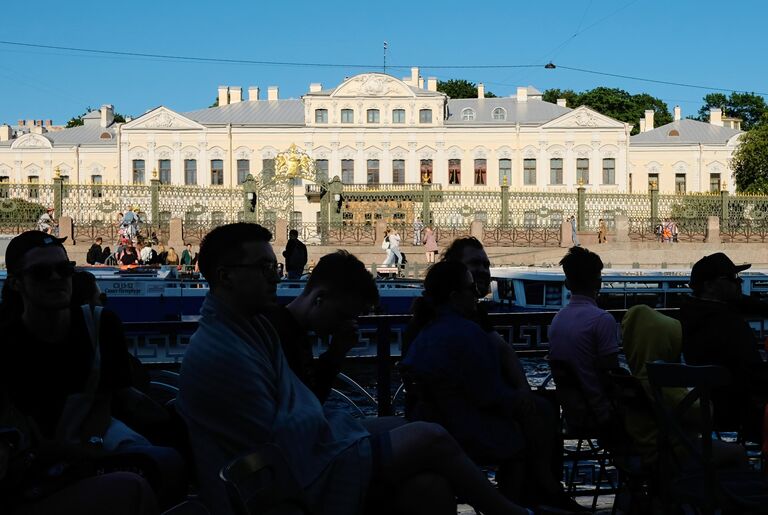 Туристы на прогулочном катере у Шереметьевского дворца в Санкт-Петербурге