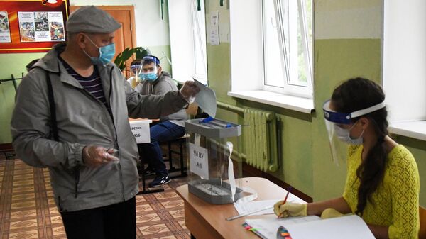 Мужчина во время голосования на избирательном участке по вопросу внесения поправок в Конституцию РФ