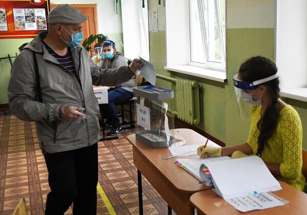 Мужчина во время голосования на избирательном участке по вопросу внесения поправок в Конституцию РФ во Владивостоке