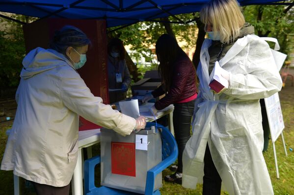 Женщина опускает бюллетень в переносную урну для голосования на избирательном участке №1409 на придомовой территории в Екатеринбурге во время голосования по внесению поправок в Конституцию РФ