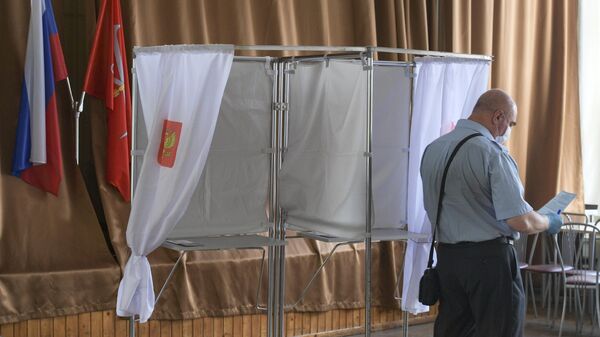 Мужчина на избирательном участке во время голосования по внесению поправок в Конституцию РФ