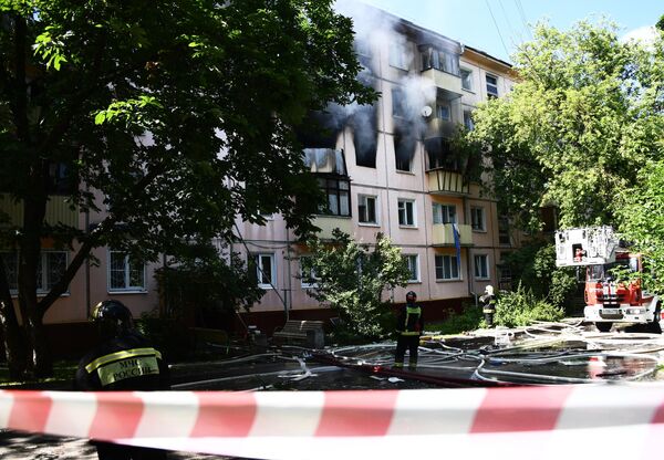 Сотрудники противопожарной службы у жилого дома на северо-востоке Москвы, где произошел хлопок газа