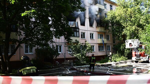 Сотрудники противопожарной службы у жилого дома на северо-востоке Москвы, где произошел хлопок газа